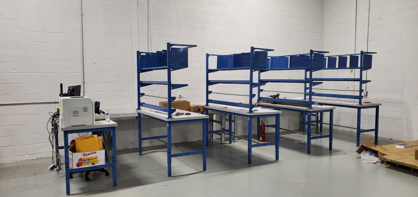 Industrial workstations with overhead shelving installation